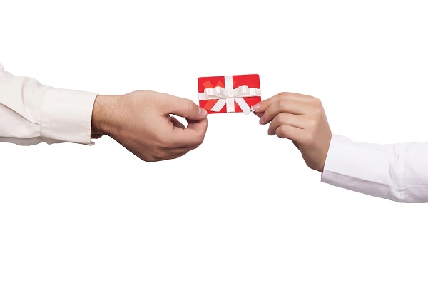 Estafas con tarjetas de regalo - Personas sosteniendo una tarjeta de regalo