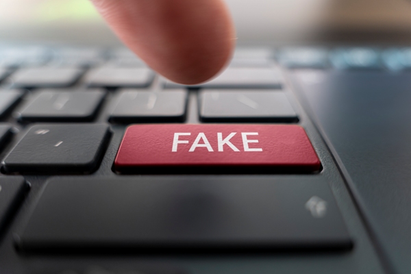 Dedo apuntando tecla para publicar fake news