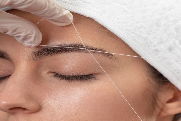 Depilación con hilo en Madrid - Depilando ceja de mujer usando un hilo