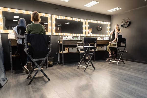 Mejores peluquerías en Madrid - Salón de belleza moderno y elegante, con espejos iluminados y estilistas trabajando en los peinados de las influencer