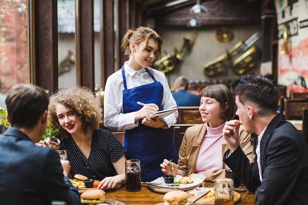 Comida tradicional - Camarera atendiendo a varios clientes en uno de los mejores restaurantes de Madrid
