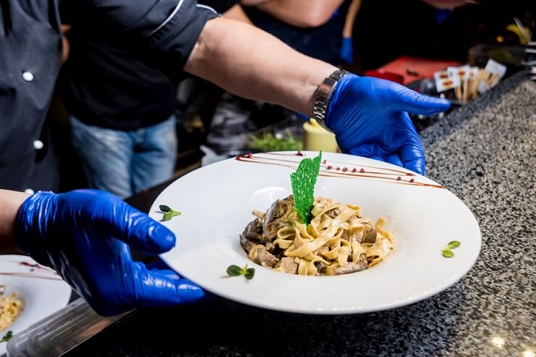 Restaurantes italianos en Madrid - Chef presentando un plato tradicional italiano, hecho con los mejores ingredientes y la receta original