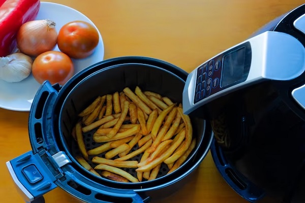 Freidora de aire - Cesta de la freidora llena de patatas, las cuales ya se cocinaron, quedando crujientes y doradas