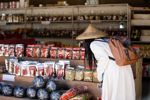Supermercados asiáticos - Mujer asiática buscando el producto que necesita en un supermercado asiático de Madrid