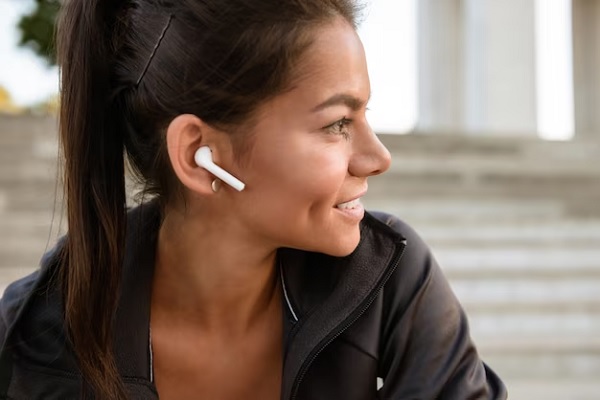 Auriculares inalámbricos - Mujer de perfil utilizando unos audífonos inalámbricos In-ear de color blanco