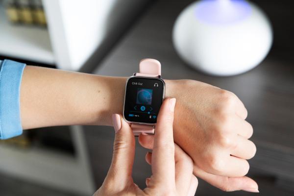 Mujer usando su smartwatch para controlar la música de manera sencilla