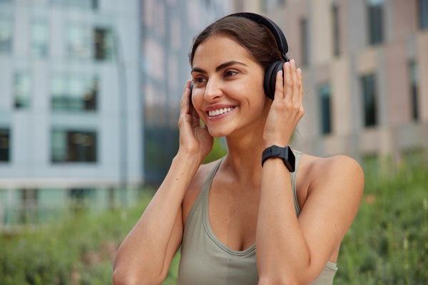 Auriculares inalámbricos - Mujer feliz al hacer ejercicio de manera cómoda con sus audífonos inalámbricos de color negro