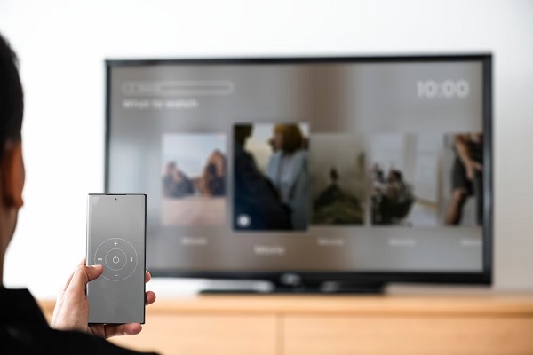 Mejor Smart tv - Hombre controlando su televisor inteligente desde el teléfono celular, para ver su película favorita