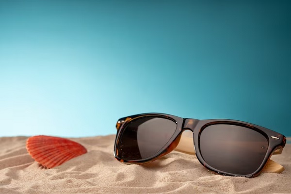 Comprar gafas de sol - Imagen de unas gafas de sol sobre la arena de una playa, las cuales protegen los ojos de los rayos UV