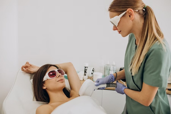 Depilación láser en Madrid - Doctora realizando un tratamiento de depilación en la axila de la paciente femenina con tecnología láser