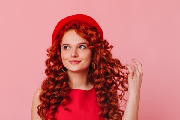Mujer con una melena de color rojo intenso, el cual aporta personalidad y atractivo durante la temporada vacacional
