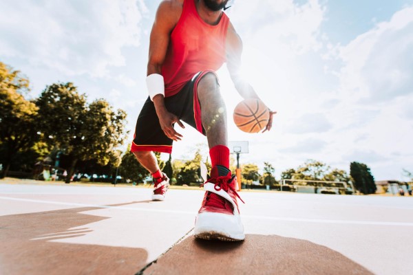 Escoger calzado deportivo correcto - Hombre jugando baloncesto con unos zapatos deportivos adecuados, los cuales ayudan a impulsar el rebote