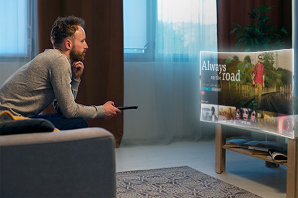 Hombre navegando en el sistema operativo de su televisor inteligente, para encontrar su película favorita