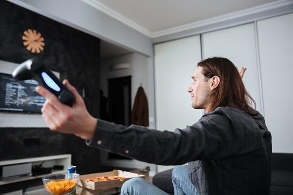 Hombre jugando en su televisor inteligente, para disfrutar de una pantalla más grande y en alta definición