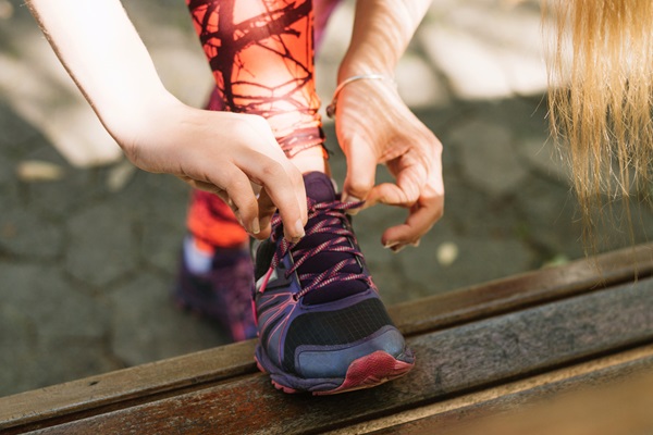 Escoger calzado deportivo correcto - Mujer colocándose unos zapatos que poseen su talla correcta, quedando el pie con un espacio suficiente para no rozar con la parte delantera