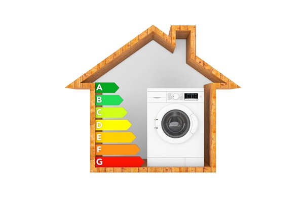 Imagen de una casa con una lavadora y la etiqueta de eficiencia energética, en referencia a tener un bajo consumo de agua y energía