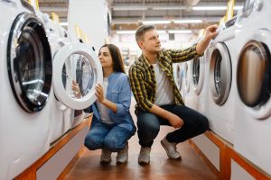 Cómo escoger una lavadora de ropa - una pareja en un almacén de electrodomésticos eligiendo una lavadora