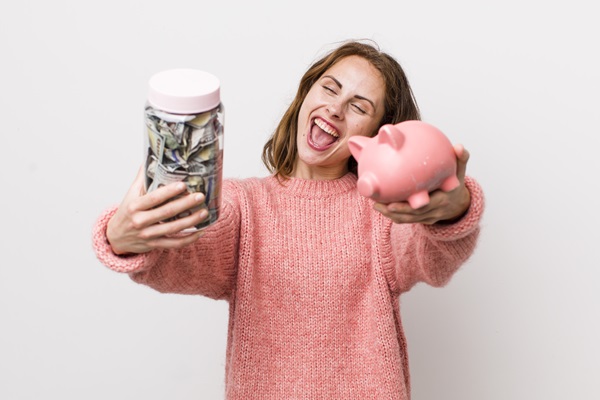Mujer feliz al ahorrar dinero en las facturas de la luz y el agua, gracias al bajo consumo de los artículos tecnológicos del hogar