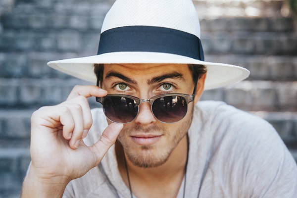 Hombre posando con lentes fotocromáticos, los cuales se adaptan a las condiciones de iluminación para proteger los ojos