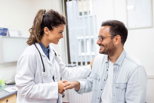 Gastroenterólogo en Madrid - Hombre se muestra sonriente y satisfecho con el trato de una doctora tras ser recibido en su consultorio