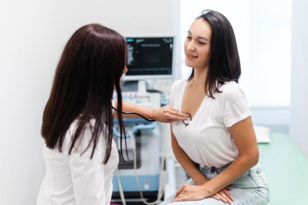 Médico profesional realizando un chequeo a una paciente femenina, para evaluar su condición de salud