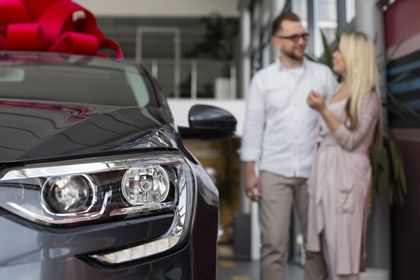 Pareja comprando un vehículo nuevo en un concesionario, luego de elegir el modelo que más se adapta a sus necesidades