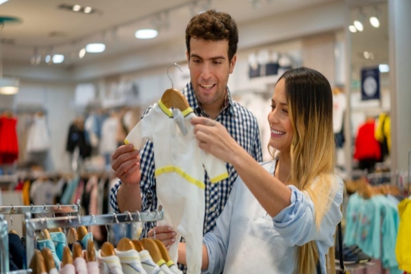 tiendas de bebé en Madrid baratas - una pareja en la tienda eligiendo ropa para el bebé