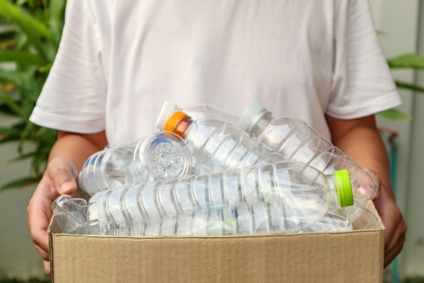 Botellas compostables - Persona sosteniendo una caja con varias botellas de plástico, las cuales se pueden reciclar