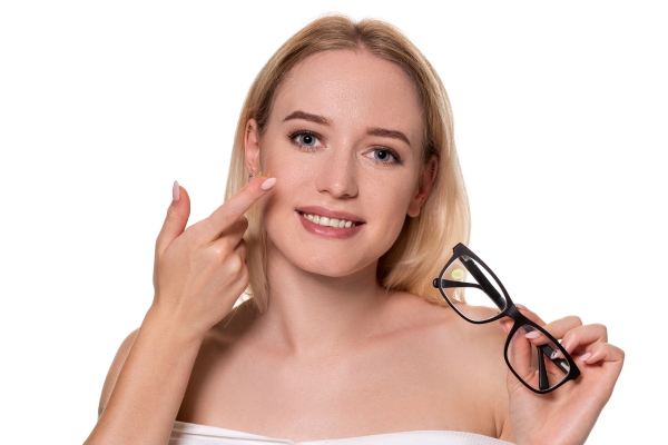 Mujer sosteniendo unas gafas tradicionales mientras señala los lentes de contacto, los cuales son más cómodos de utilizar y ofrecen una visión natural