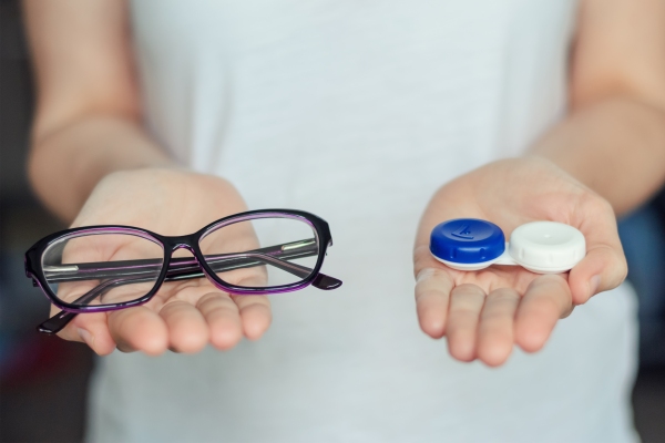 Lentillas progresivas - Imagen comparativa de una persona sosteniendo unas gafas tradicionales y un estuche de lentillas progresivas