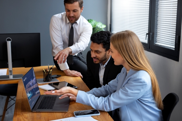 Equipo de trabajo utilizando una computadora de la organización para observar los gráficos y analizar la información