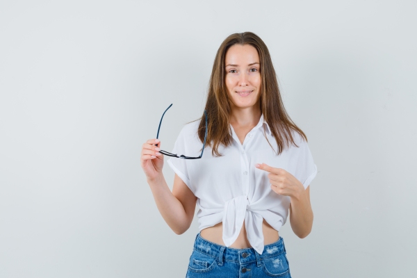 Mujer sosteniendo unas gafas tradicionales, las cuales ayudan a solucionar problemas visuales sin tener un coste elevado