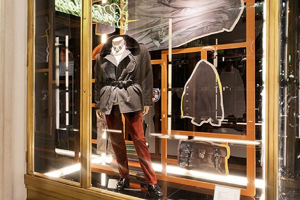 tiendas de ropa en Barcelona - Maniqui en vitrina exhibe un atuendo casual con chaqueta gruesa de invierno y pantalón de pana
