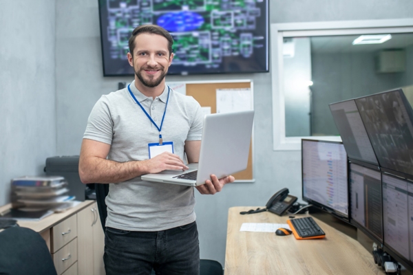 Empresa de servicios informáticos - Hombre contento al manejar adecuadamente los equipos y sistemas informáticos de una empresa