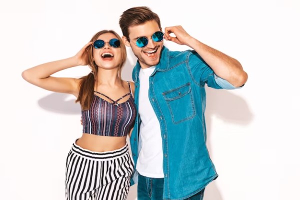 Gafas de sol - Pareja posando feliz sosteniendo unas gafas de sol que combinan con su estilo y outfit