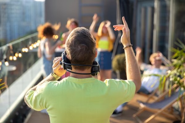 Tendencias musicales - DJ colocando música en una fiesta privada, donde las personas disfrutan de bailar y cantar sus canciones favoritas