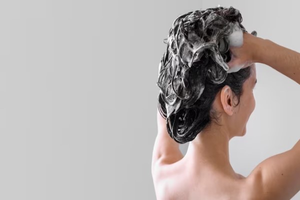 Champú sin parabenos - Mujer lavando su cabello con un champú especial, el cual le ayuda a hidratar y revitalizar el pelo