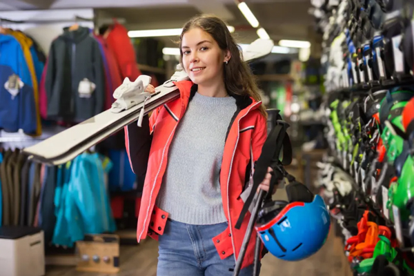 Tiendas de artículos deportivos - Mujer comprando varias herramientas para practicar esquí en una de las mejores tiendas deportivas en Madrid