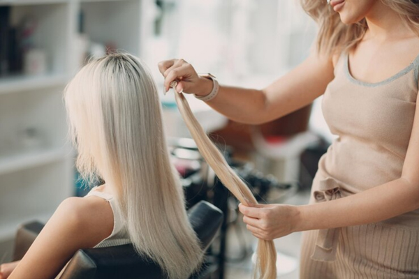 Extensiones de pelo - Estilista en Madrid aplicando extensiones de cabello a una clienta, para crear un nuevo look que destaque su belleza natural