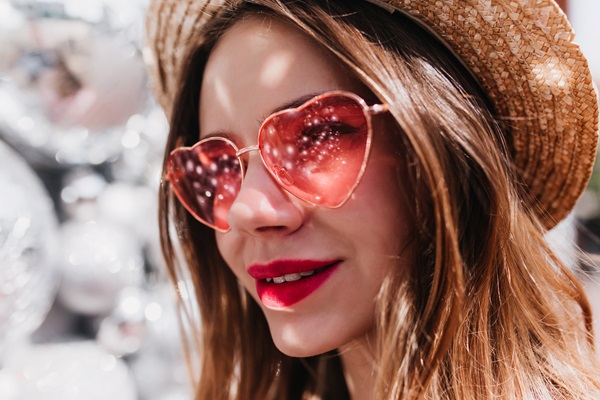 Mujer utilizando unos lentes extravagantes en forma de corazón que hacen resaltar su estilo