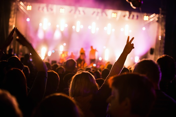 Personas disfrutando un concierto de su banda favorita en un festival de música