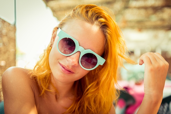 Mujer utilizando unos lentes con un diseño moderno y único, el cual hace resaltar su estilo
