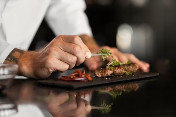 Restaurantes preferidos por los chefs españoles - Chef utiliza herramientas especiales para darle el toque final a la presentación de un plato de carne en Madrid