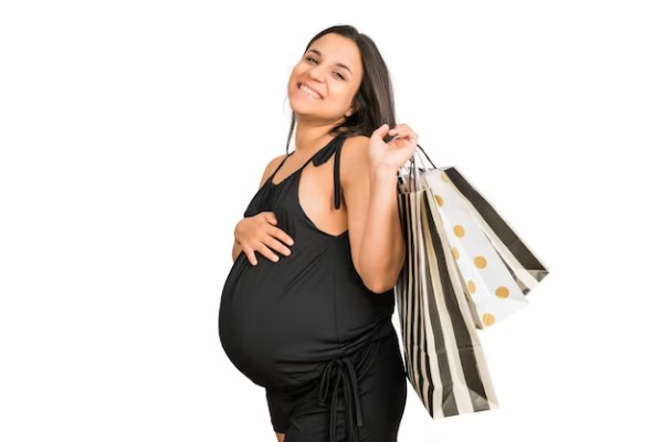 Tiendas de ropa de embarazada - Retrato de mujer embarazada sonriente sosteniendo varias bolsas de compra en Madrid