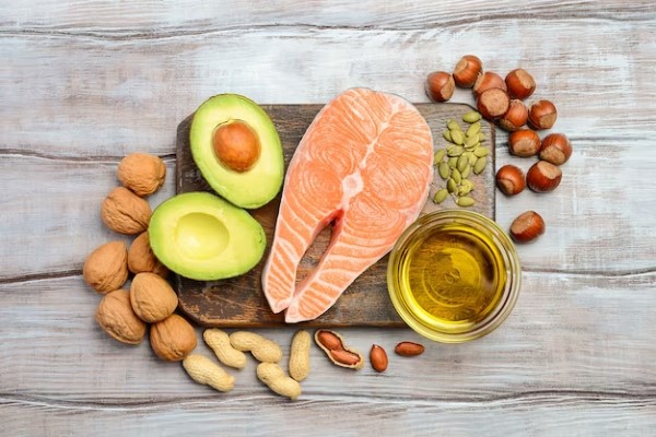 Propuestas gastronómicas 2024 - Vista cenital de una rueda de salmón fresca acompañada de frutos secos, aguacate y aceite de oliva