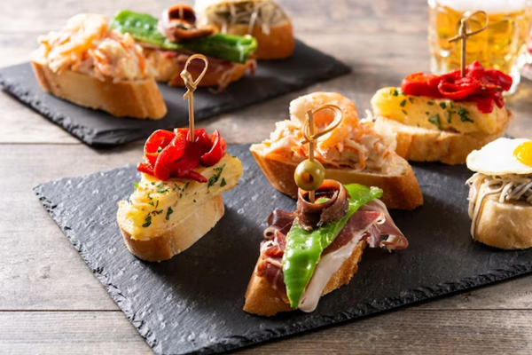 Ciudades gastronómicas de España - Vista parcial de una variada oferta de pintxos típicos de San Sebastián servidos en tablas de madera