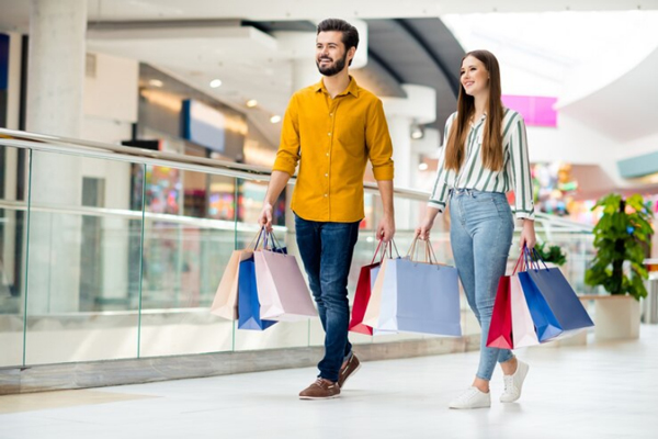Tiendas más populares de España - Pareja joven visiblemente feliz haciendo compras en un centro comercial de Madrid
