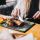 Los 10 mejores restaurantes de Madrid - Joven rubia con cuchillo y tenedor en mano disfruta de un pescado al horno con hierbas y verduras sobre la mesa