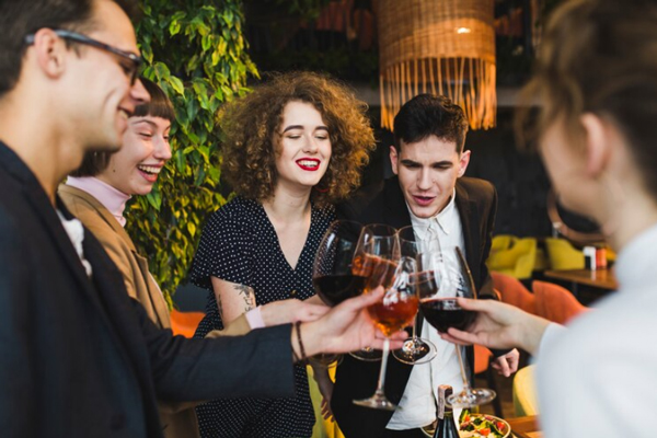 Restaurantes en Madrid - Grupo de personas jóvenes brindando con copas de vino en un restaurante