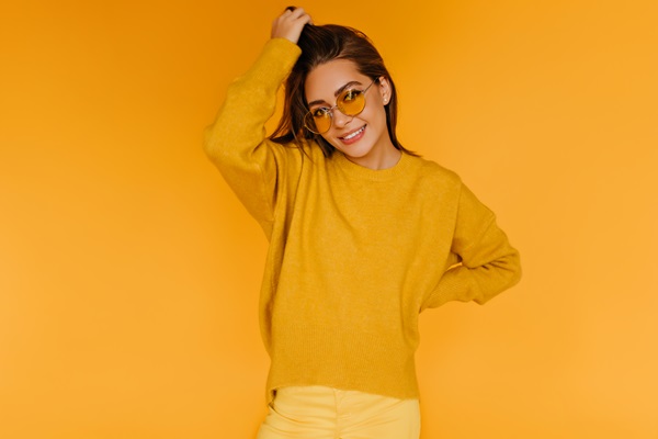 Mujer posando con un suéter de color mostaza y un pantalón amarillo, combinación que la hace lucir casual y sociable